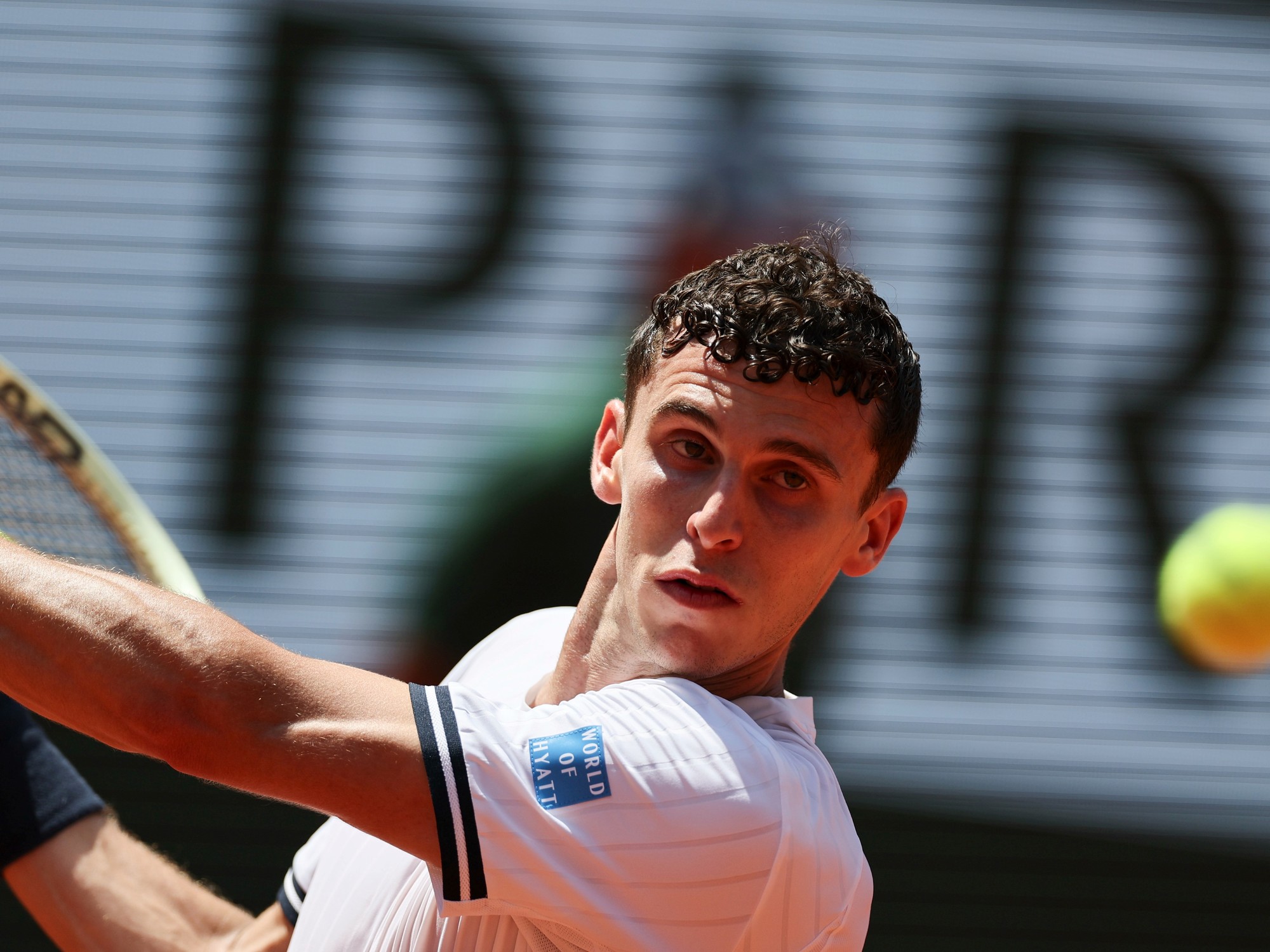 Juan Manuel Cerúndolo ejecutando un golpe de revés en la cancha de Roland Garros.