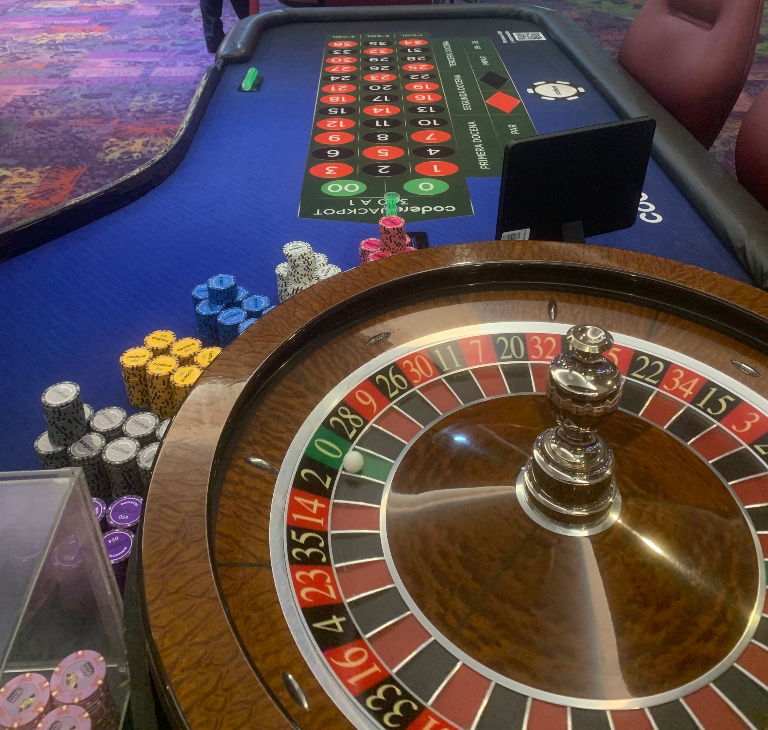 Una ruleta de casino con fichas y una mano apunto de lanzar la bola
