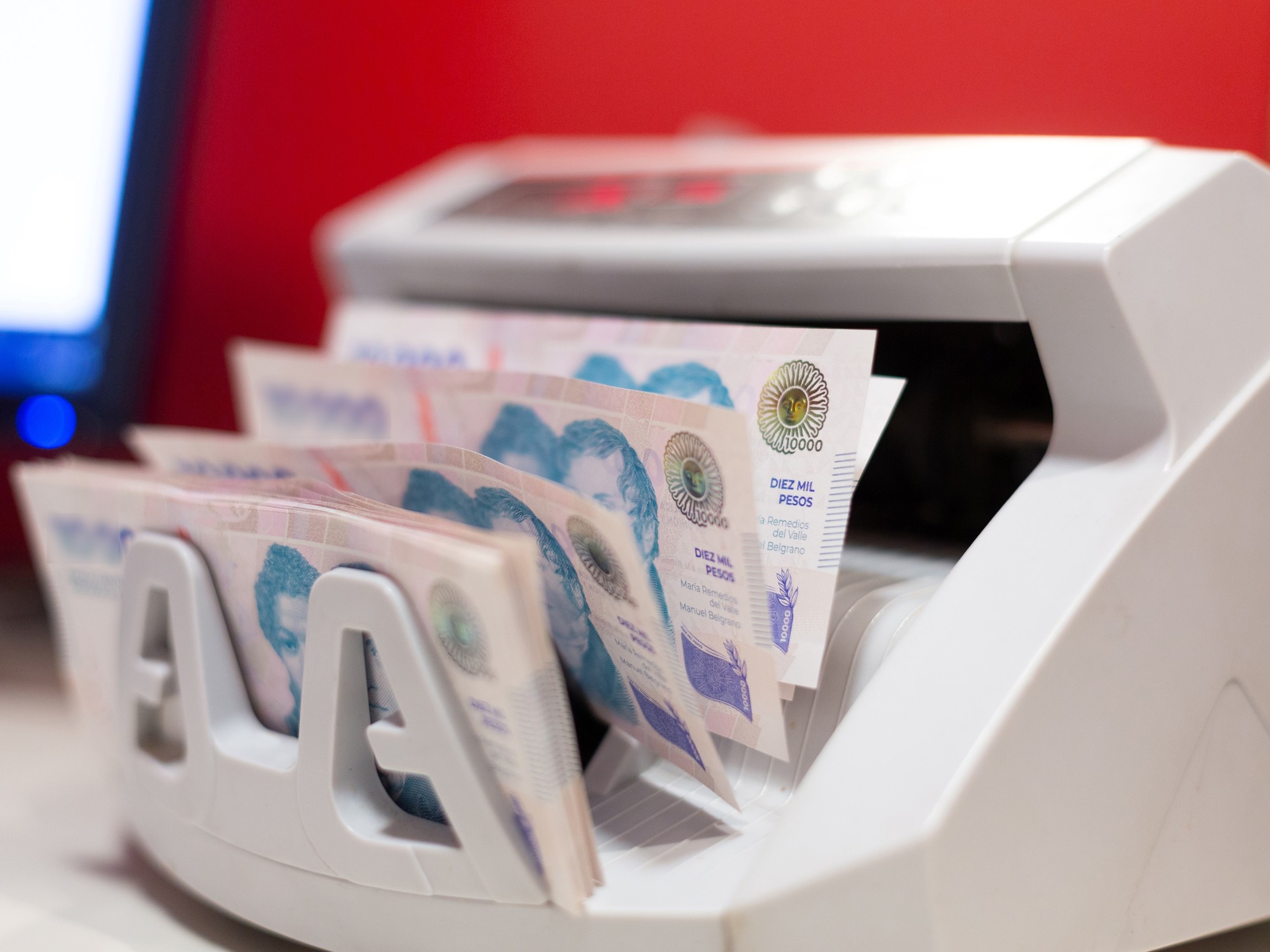 Empleados en una oficina discutiendo gráficos de aumentos salariales en Argentina