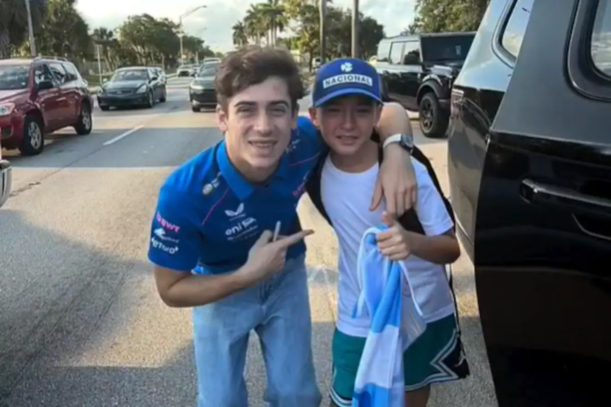 Franco Colapinto firmando una bandera argentina a un joven fanático en Miami