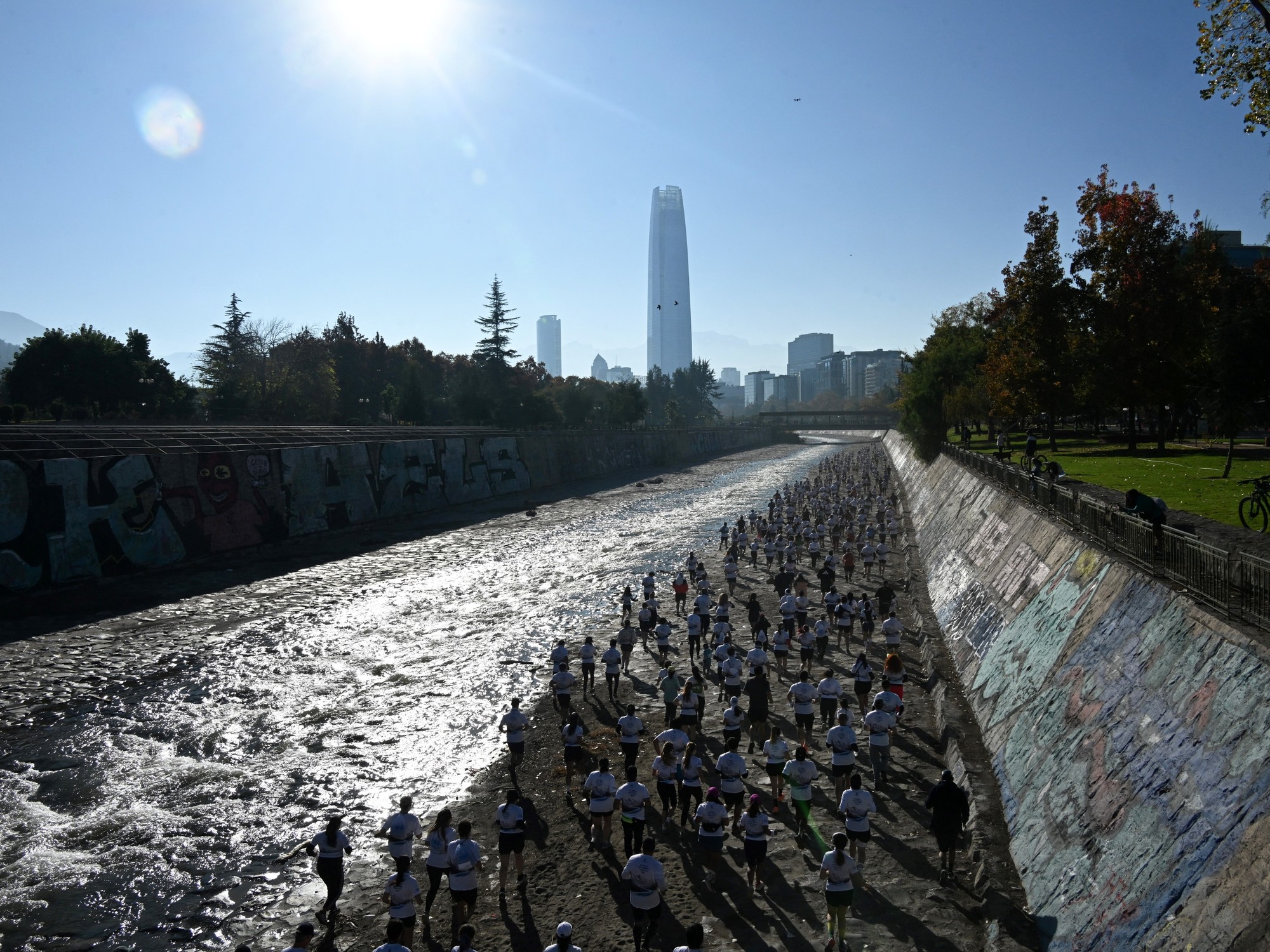 Personas corriendo y disfrutando de la renovada ribera del río Mapocho en Santiago de Chile.