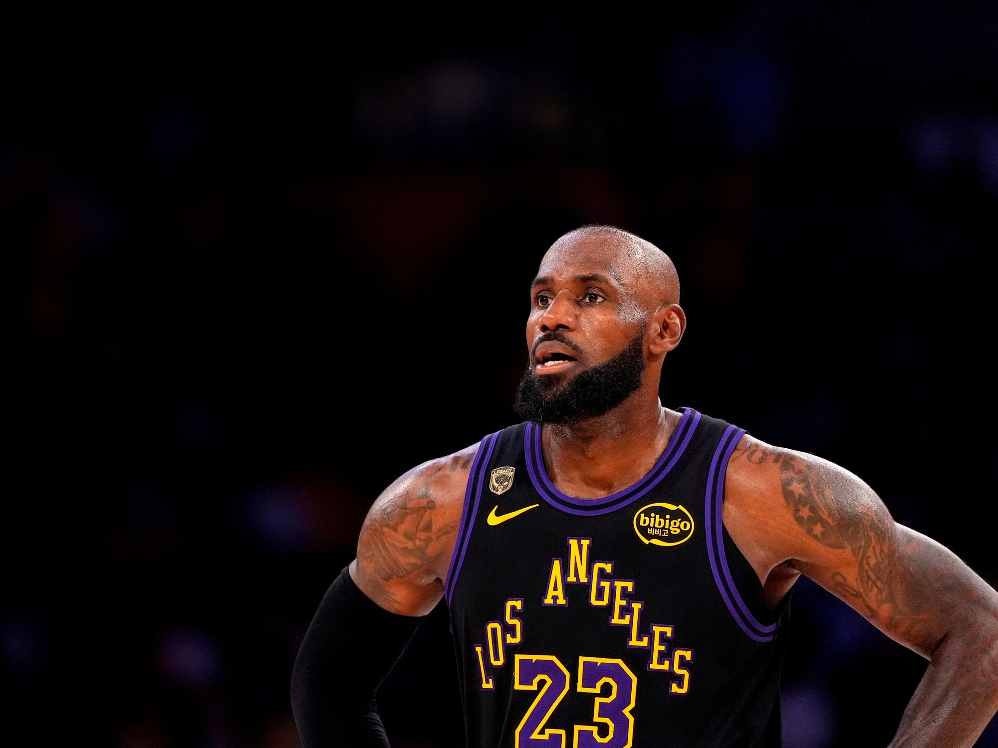 LeBron James en la cancha de baloncesto, pensativo, con la camiseta de Los Angeles Lakers.