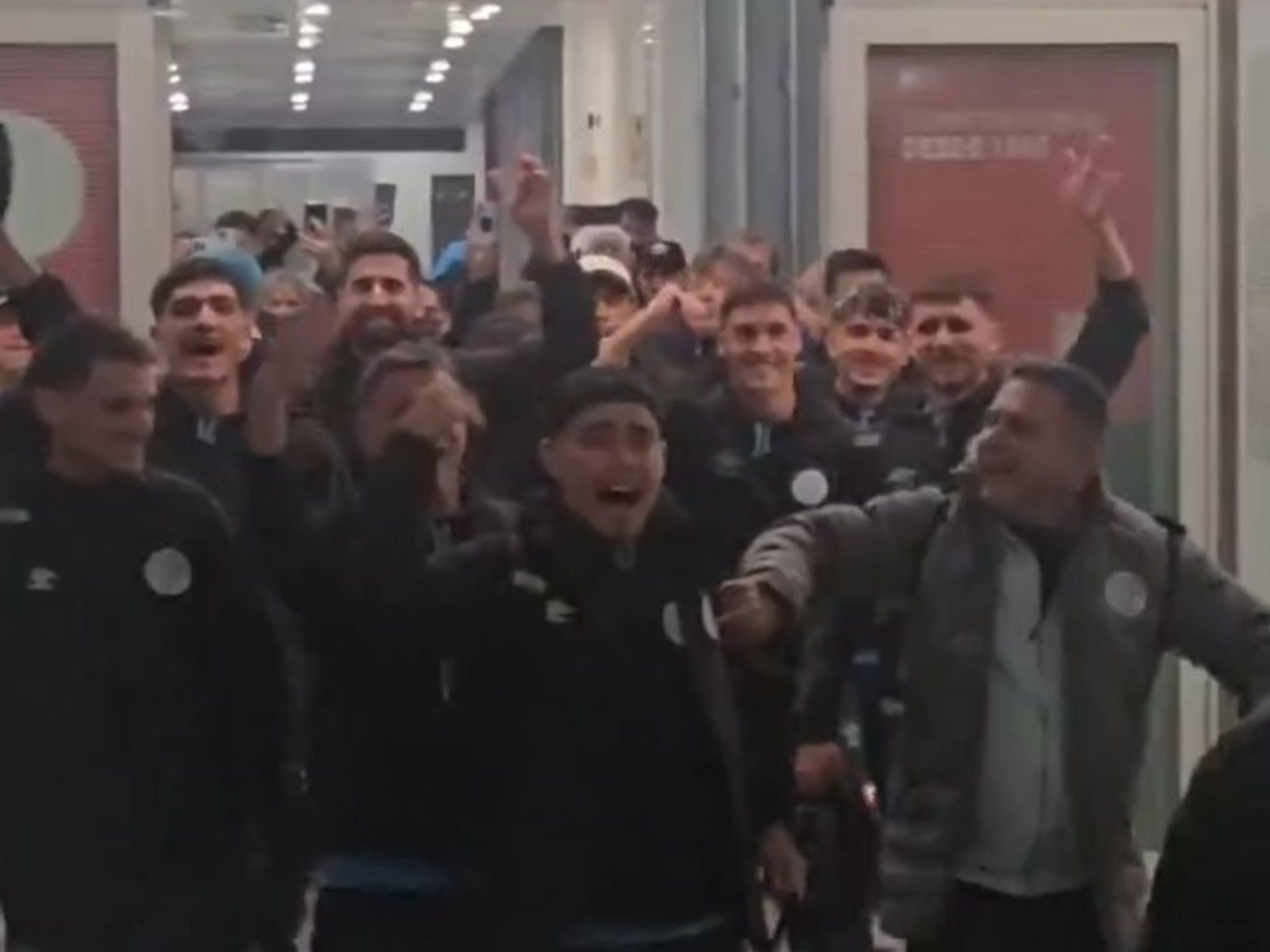Hinchas de Belgrano con banderas y cánticos en el aeropuerto de Córdoba recibiendo al equipo.