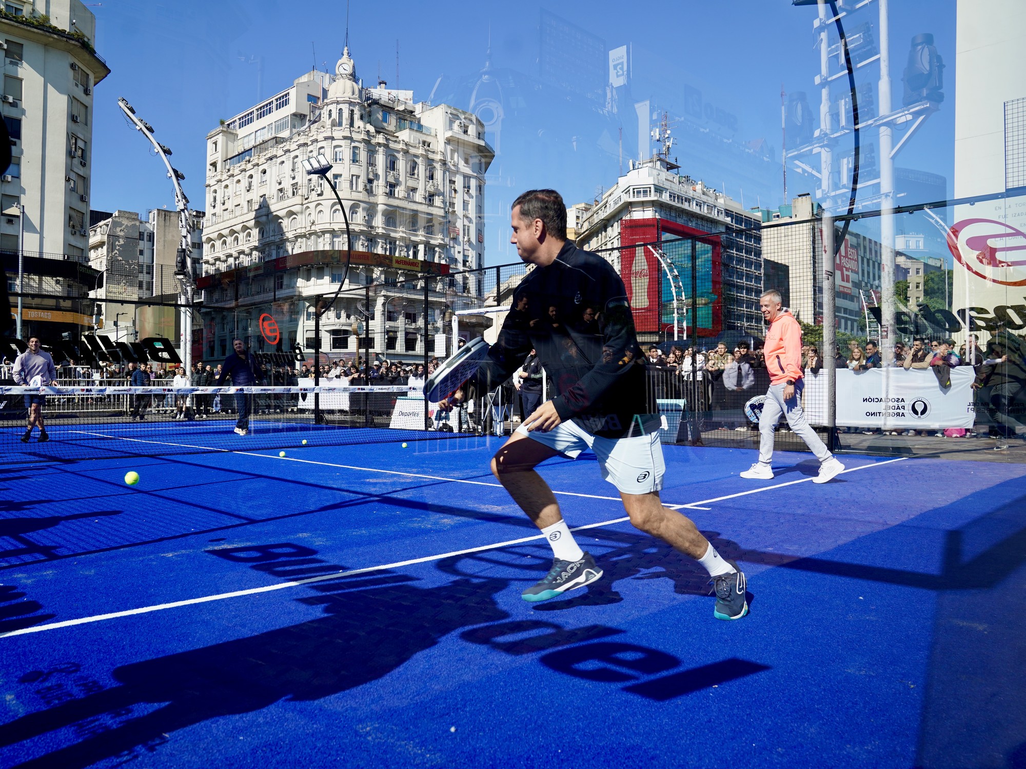 Jugadores de pádel y público en una cancha montada frente al Obelisco de Buenos Aires.