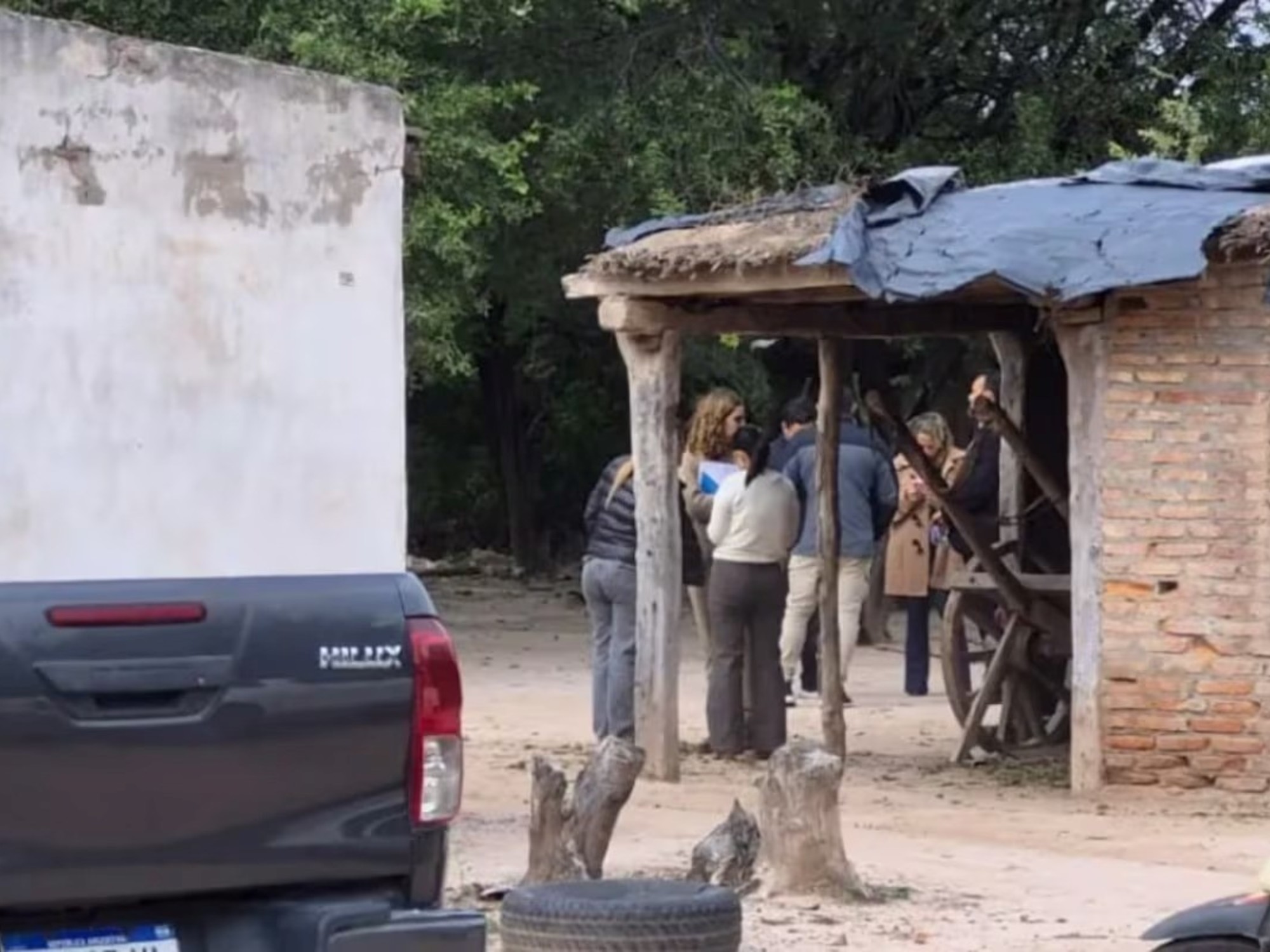 Efectivos policiales y vehículos frente a una casa rural durante un allanamiento en Santiago del Estero.