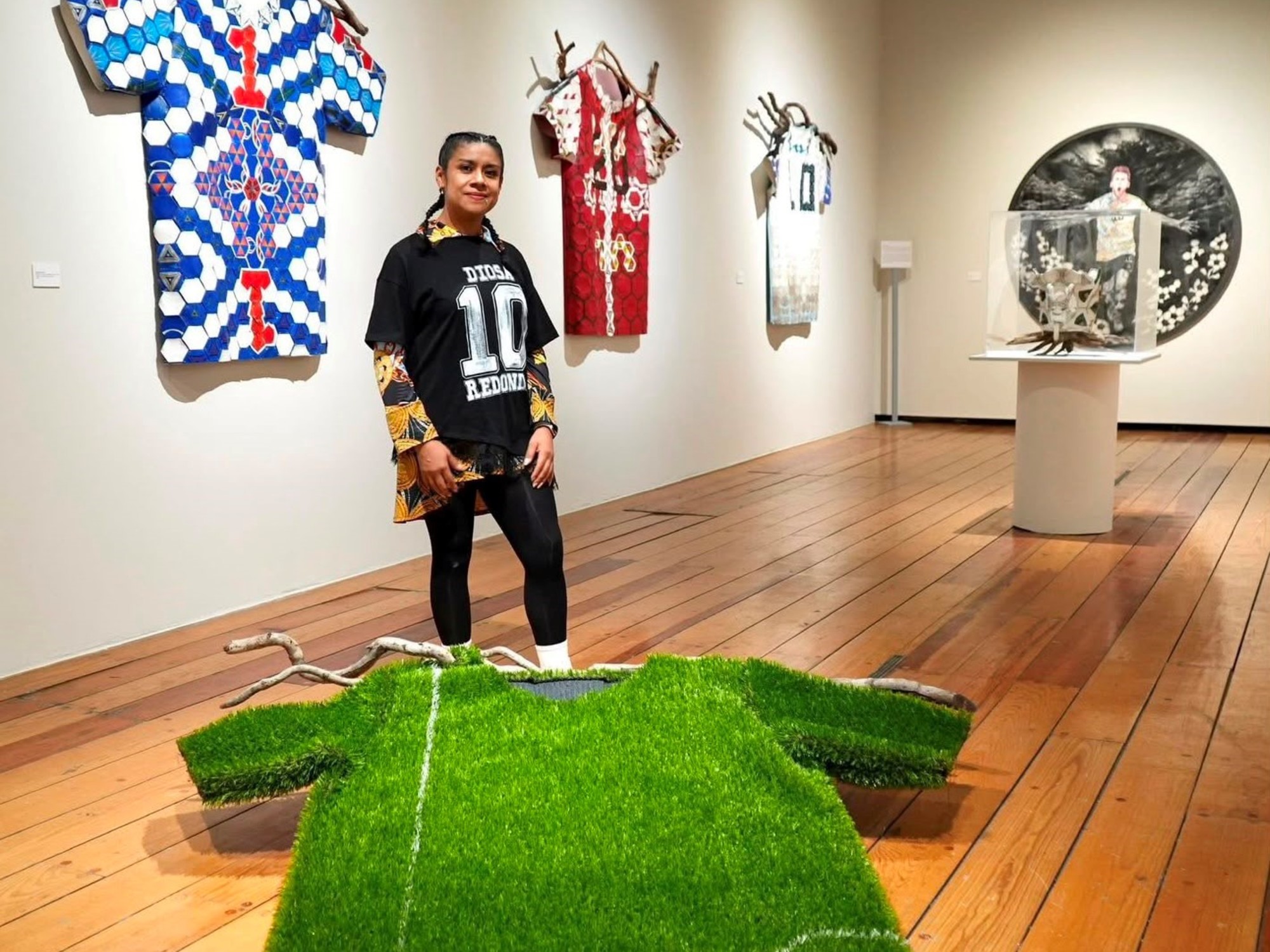 Aficionados observando obras de arte inspiradas en el fútbol en una galería.