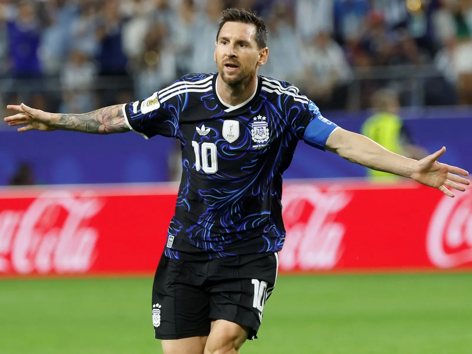 Lionel Messi levanta los brazos en señal de celebración tras anotar un gol para la Selección Argentina en un partido de Copa del Mundo.