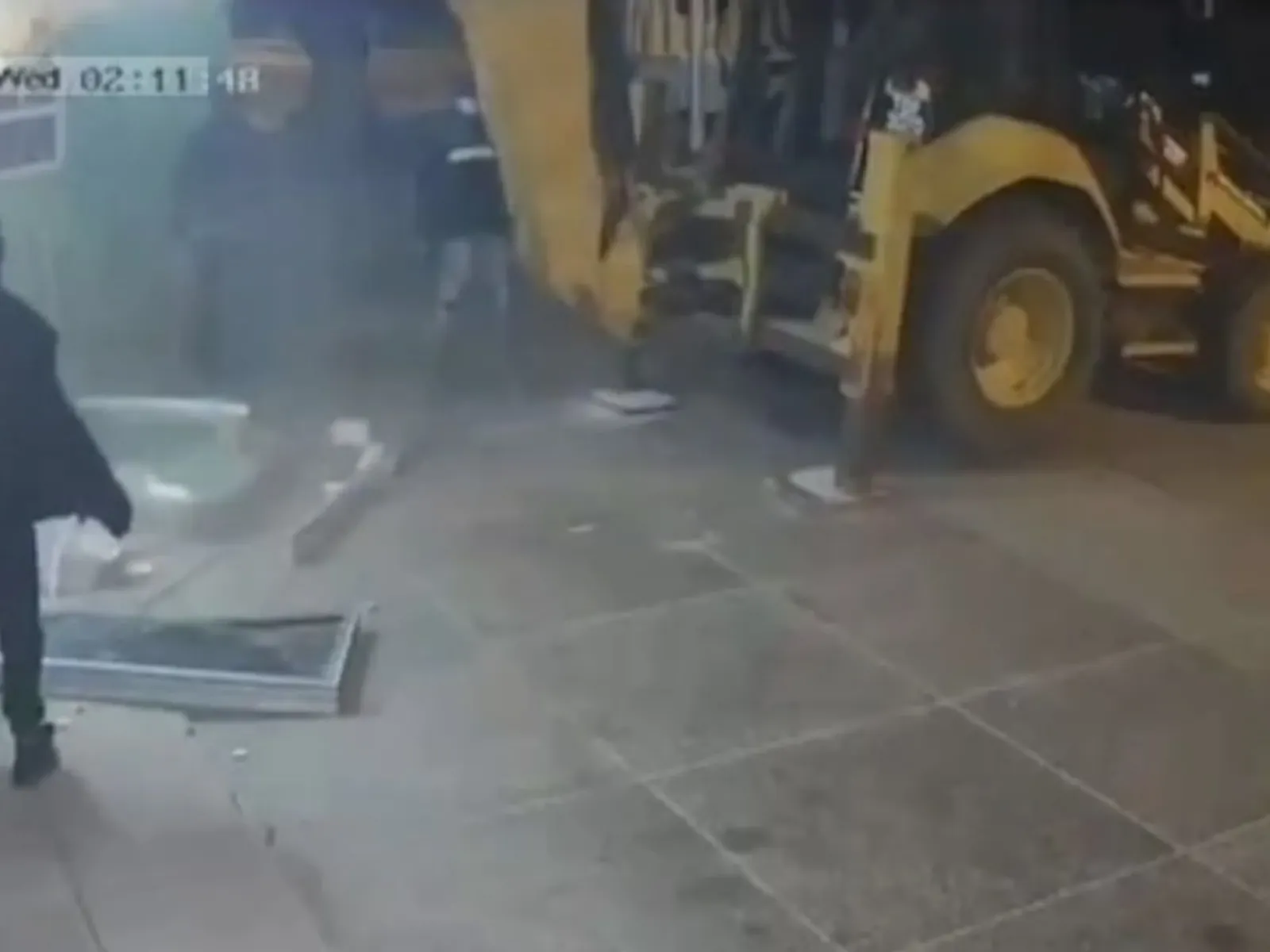 Captura de video de cámaras de seguridad que muestra a un grupo de personas intentando robar un cajero automático con una retroexcavadora.
