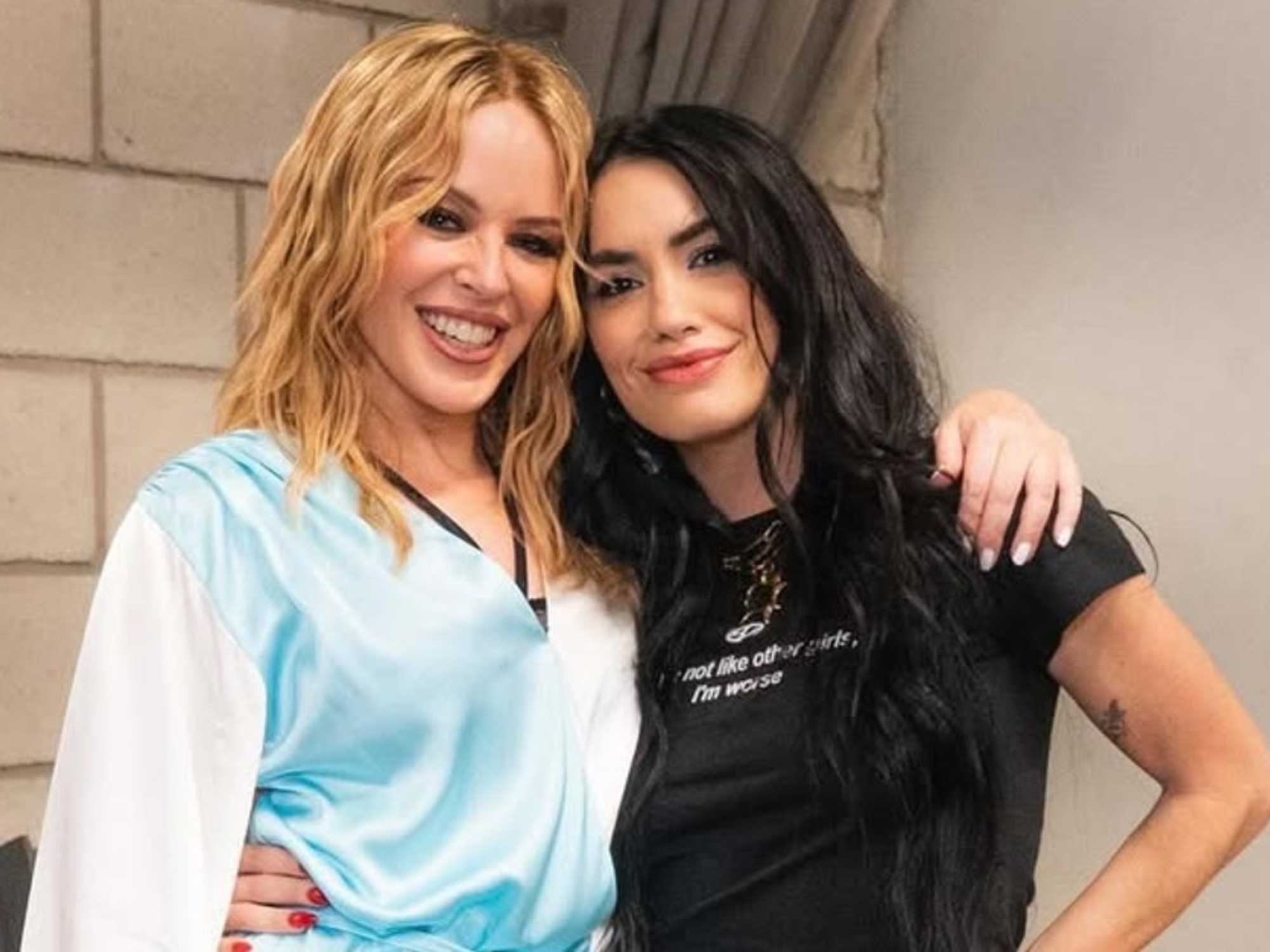 Kylie Minogue saluda a fans que la esperan a la salida de un hotel en Puerto Madero.