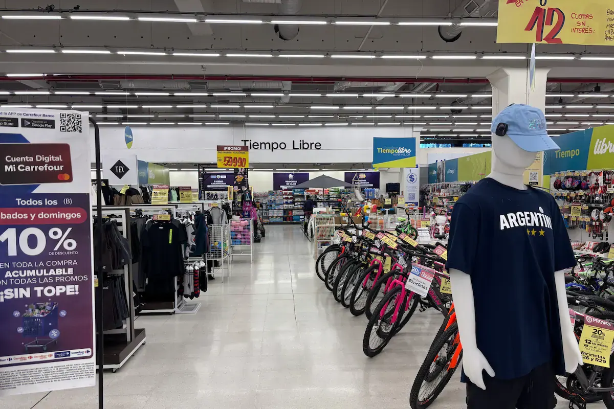 Grupo de personas observando un partido de fútbol en una pantalla en un centro comercial.