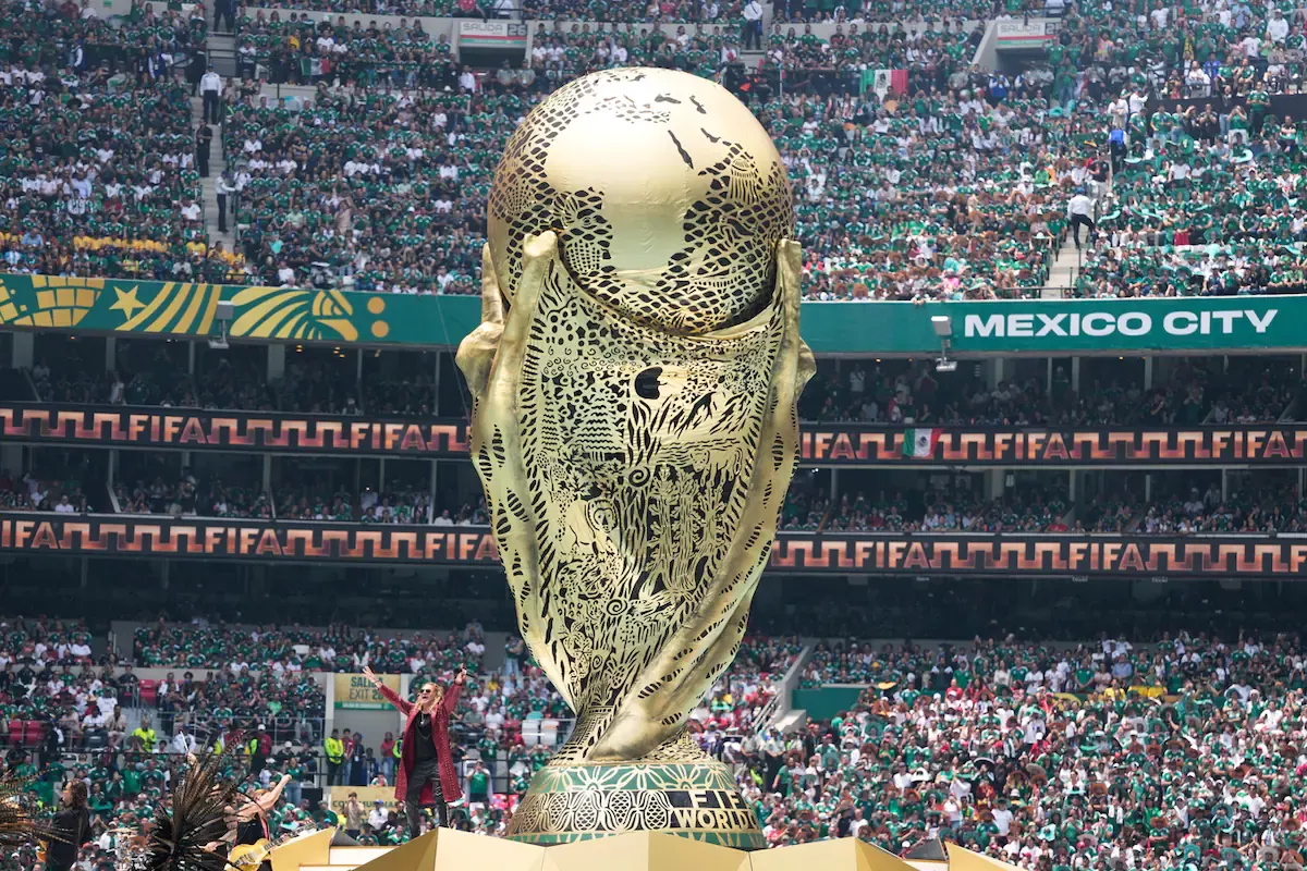 Estadio con aficionados vibrando durante un partido de la fase de grupos del Mundial 2026.