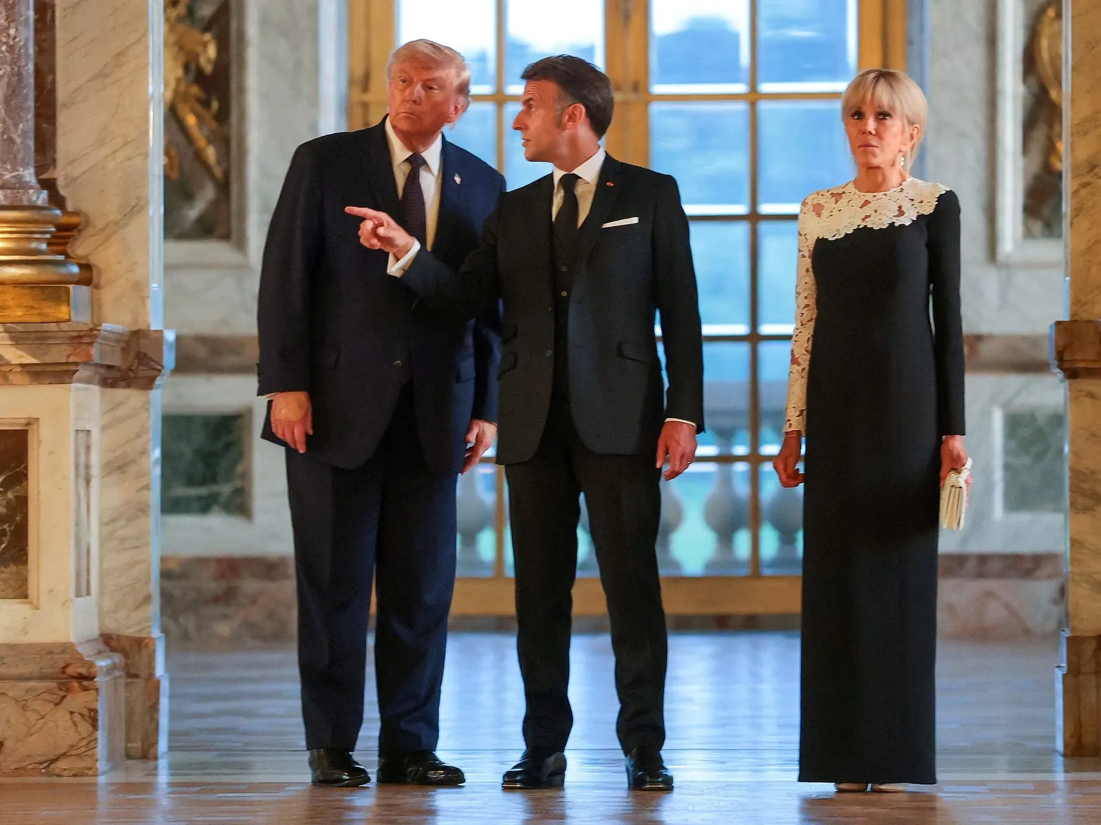 El presidente francés Emmanuel Macron y su esposa Brigitte Macron reciben al presidente estadounidense Donald Trump en la entrada del Palacio de Versalles.