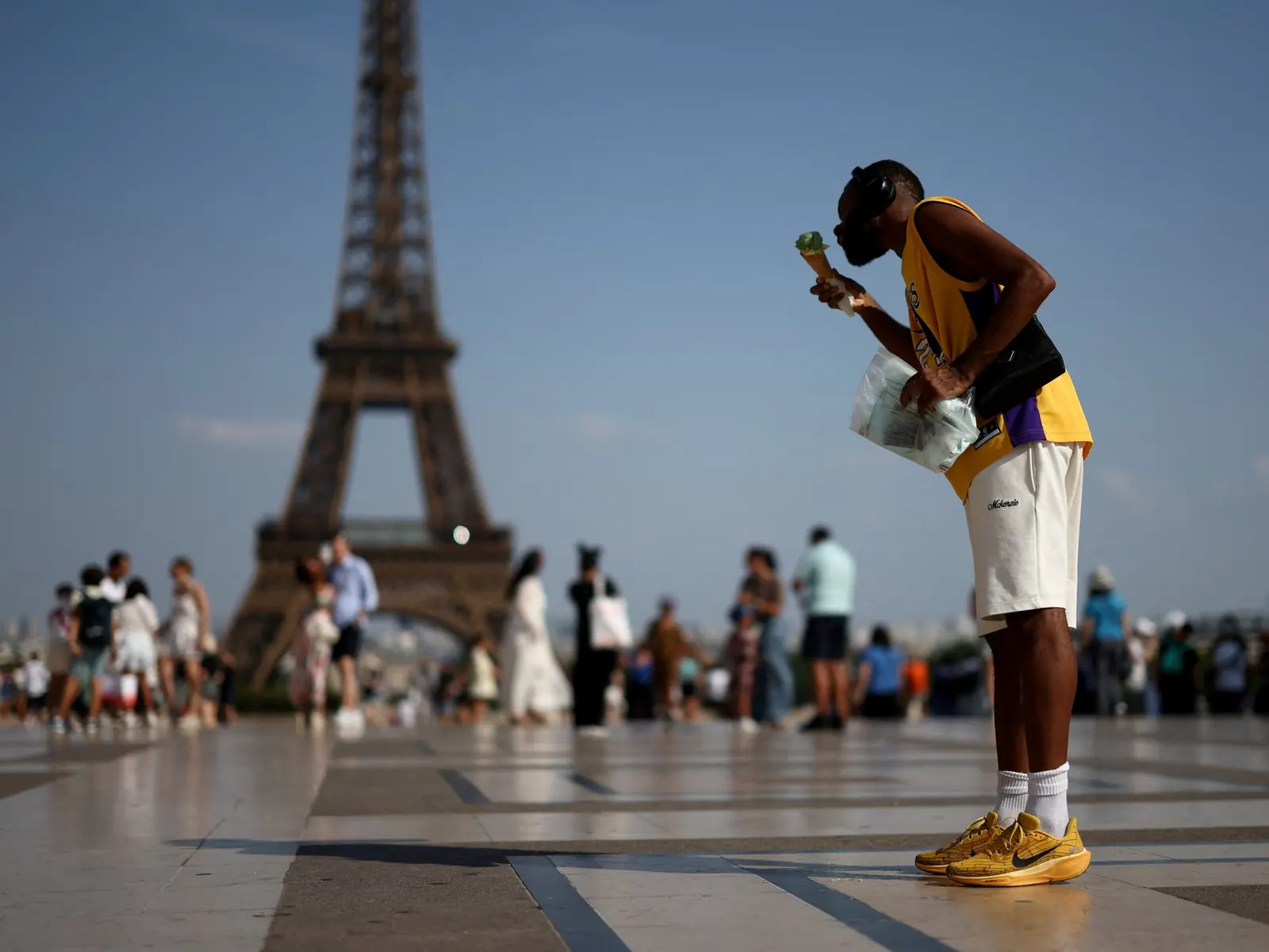 Personas se refugian del sol bajo sombrillas frente al Museo del Louvre en París, Francia, durante una ola de calor.