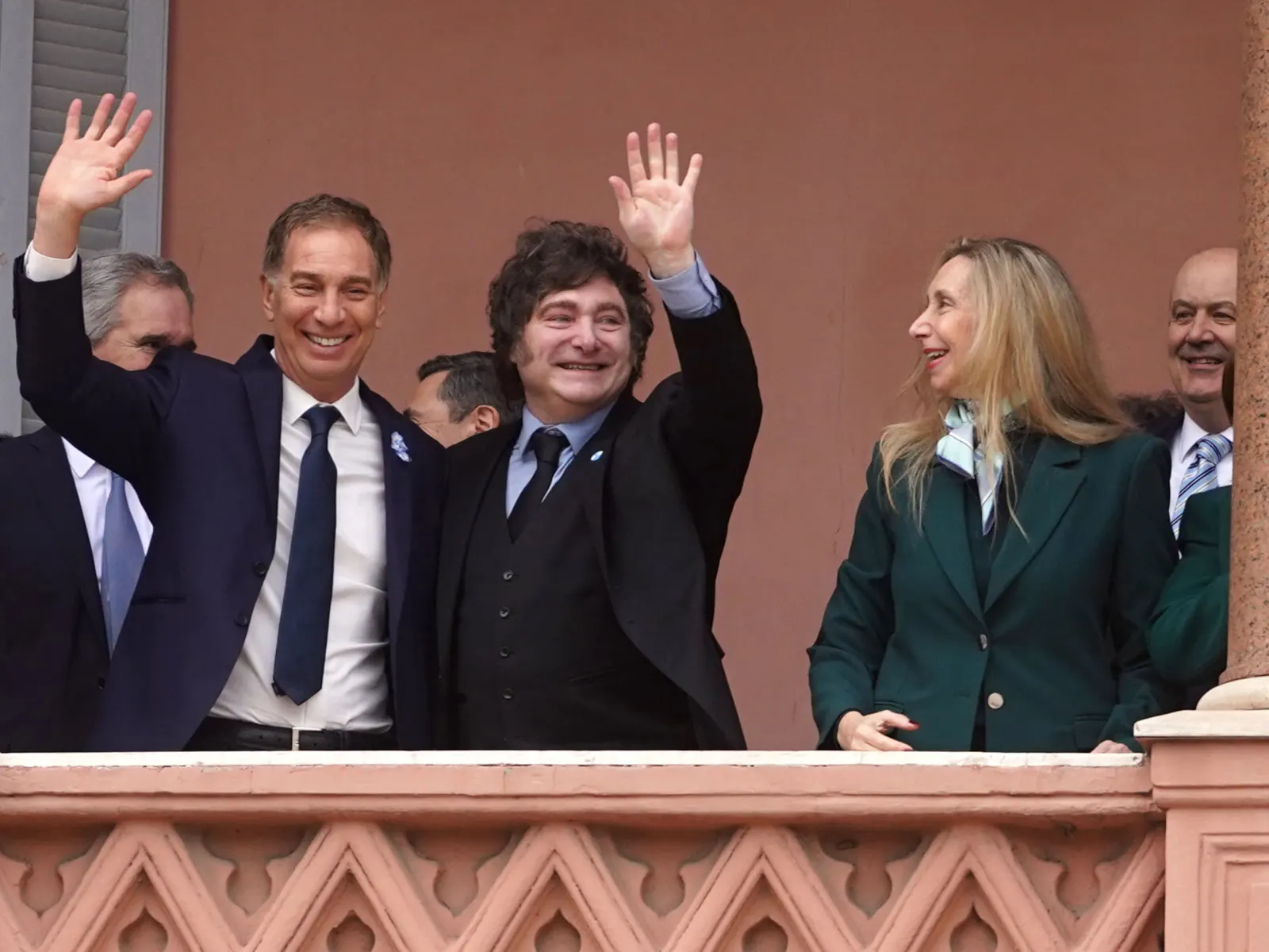 El Presidente Javier Milei, rodeado de ministros y asesores, saliendo al balcón de la Casa Rosada.