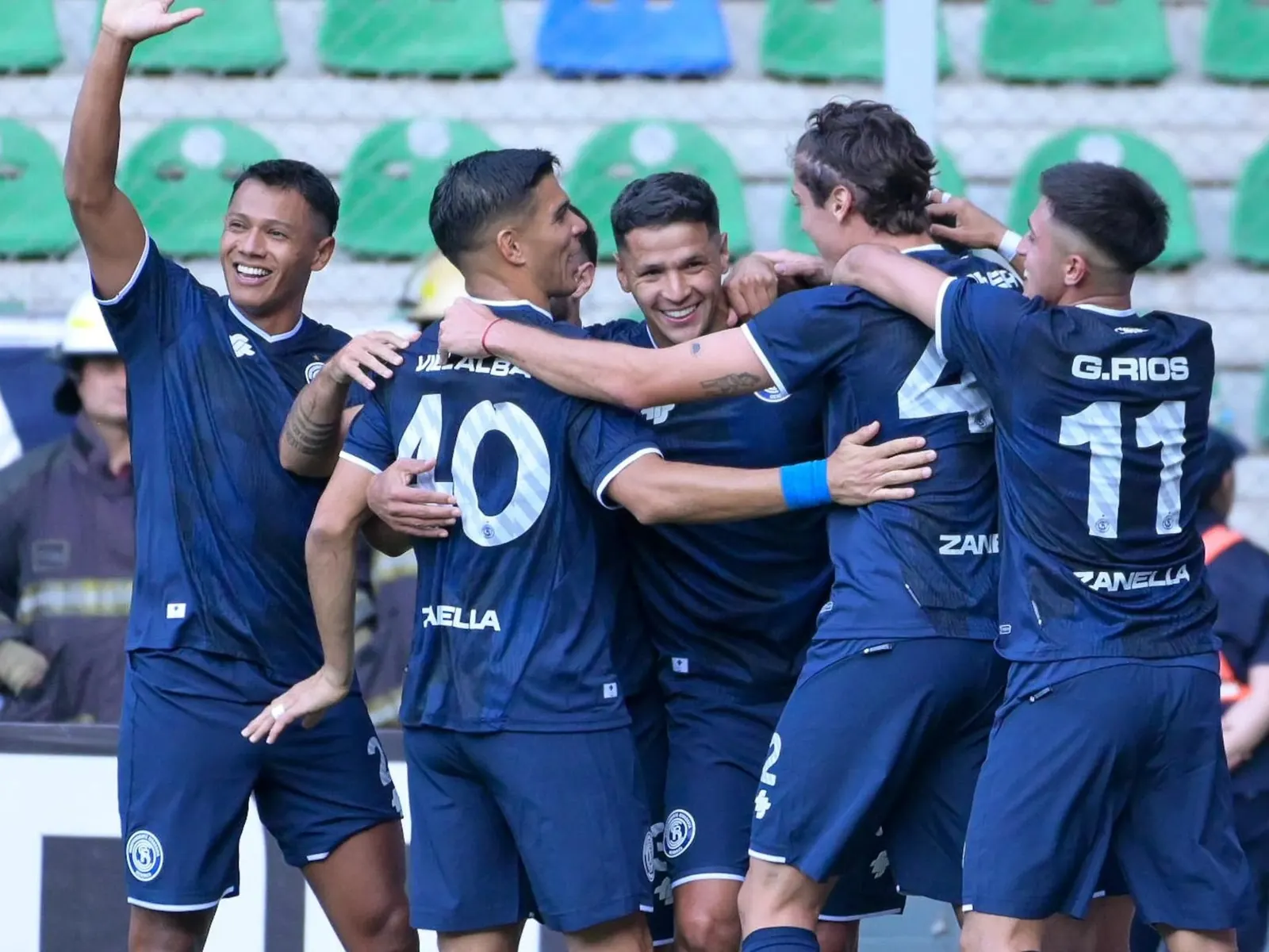 Jugadores de fútbol disputando un partido en una cancha argentina.