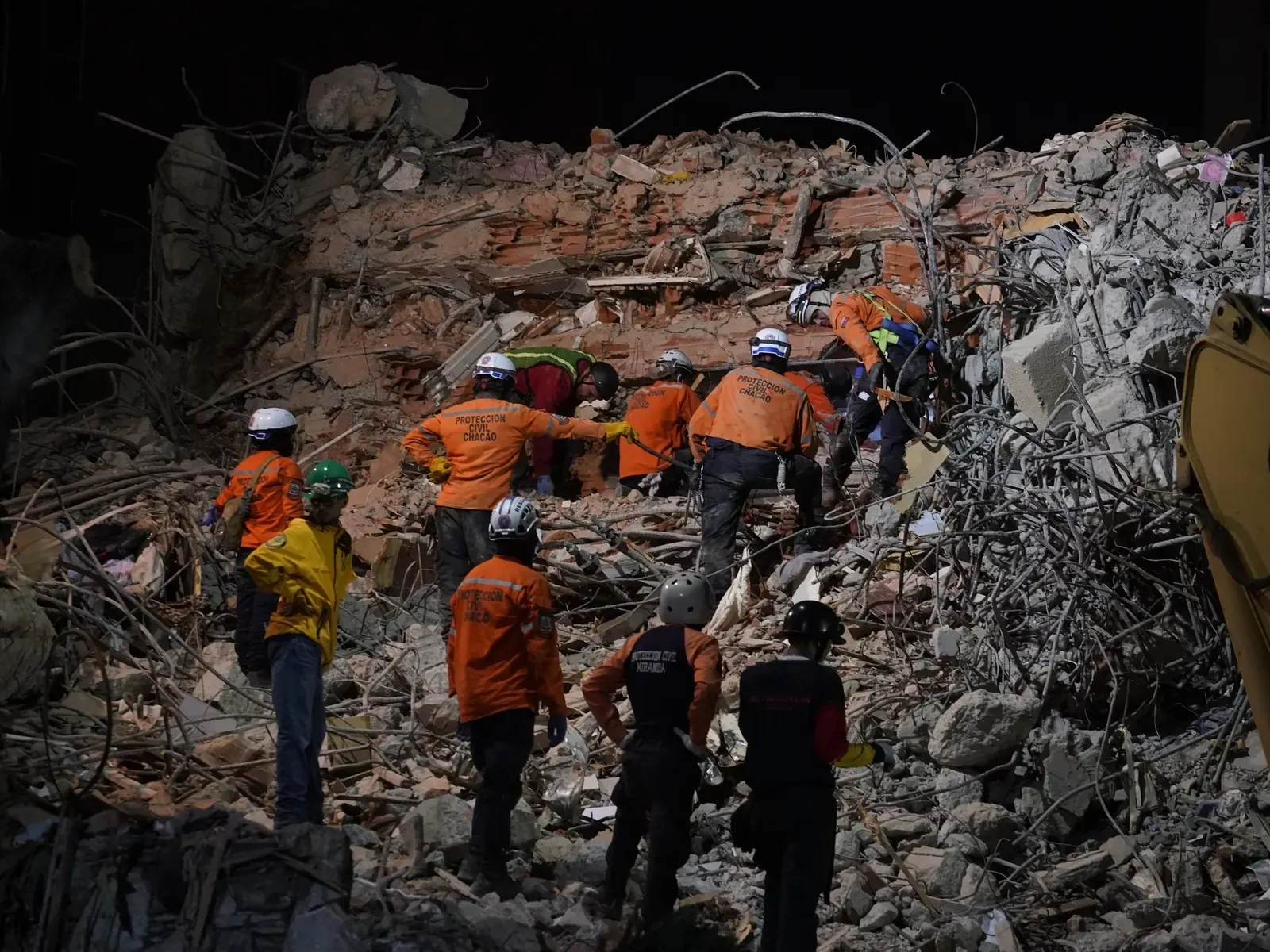 Equipo de rescatistas internacionales colaborando en la búsqueda de sobrevivientes en una zona de derrumbe en Venezuela.