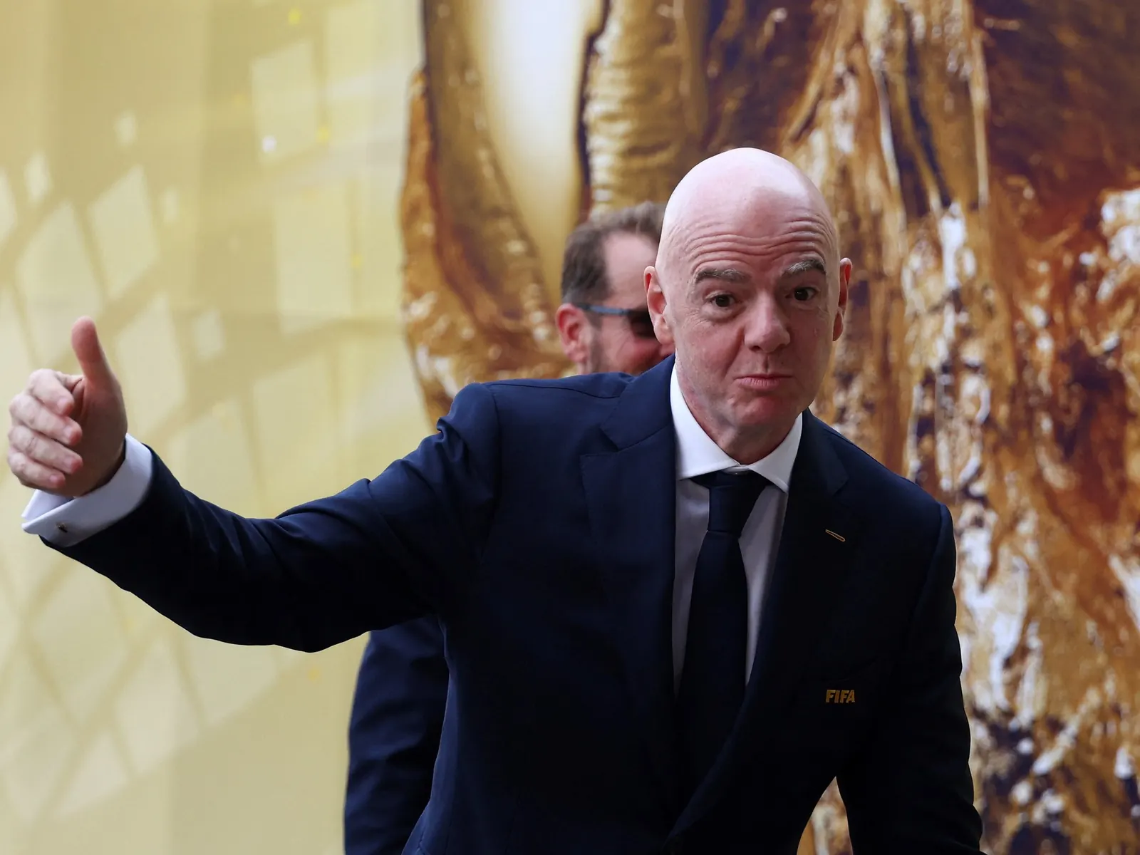 Gianni Infantino, presidente de la FIFA, junto a una imagen de Nicolás Otamendi con la Copa del Mundo.