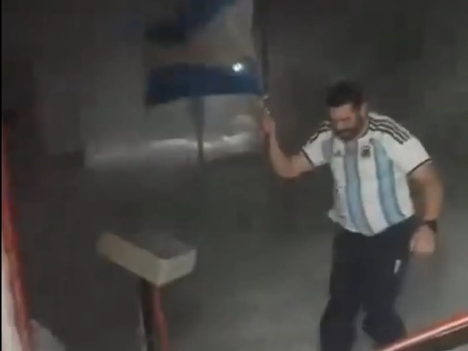 Un docente con la camiseta de la Selección Argentina y una bandera nacional celebra en medio de la nieve y el frío de la Antártida.