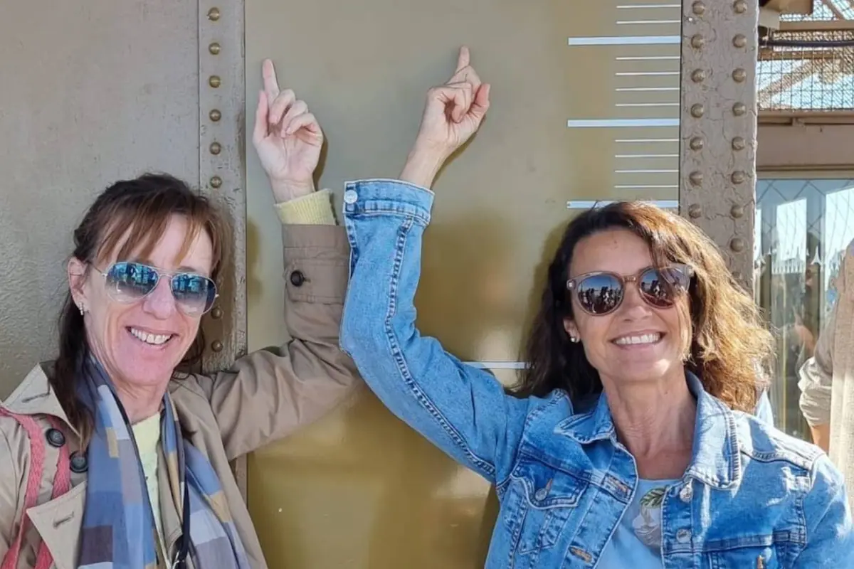 Dos mujeres argentinas sonriendo mientras pasean por una calle de París, Francia.