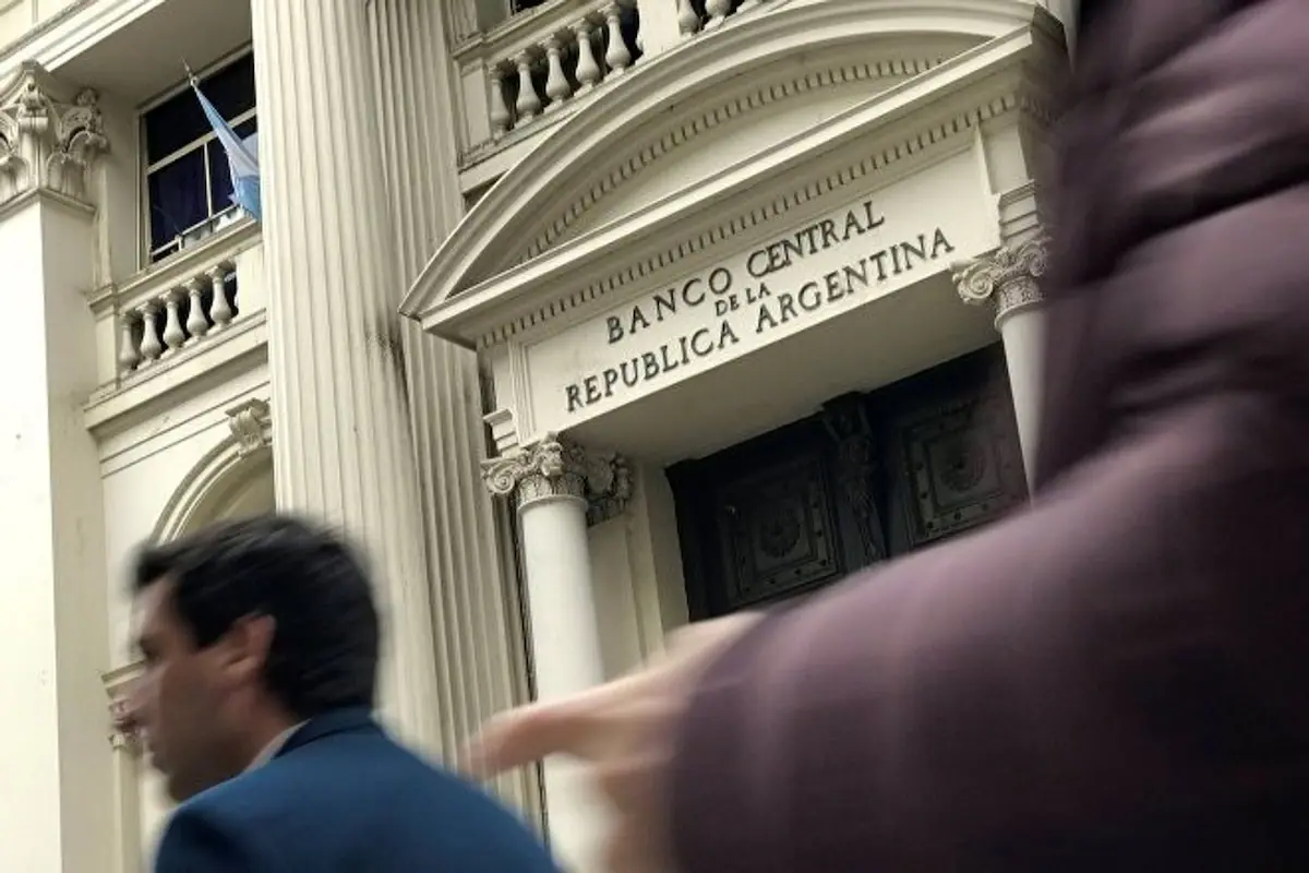 Edificio del Banco Central de la República Argentina (BCRA) con billetes de dólares apilados.