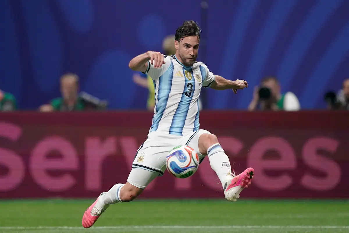 Nicolás Tagliafico sostiene la medalla de plata del Mundial 2026 en primer plano, con la cinta azul y dorada en su muñeca, sobre la palma de su mano.