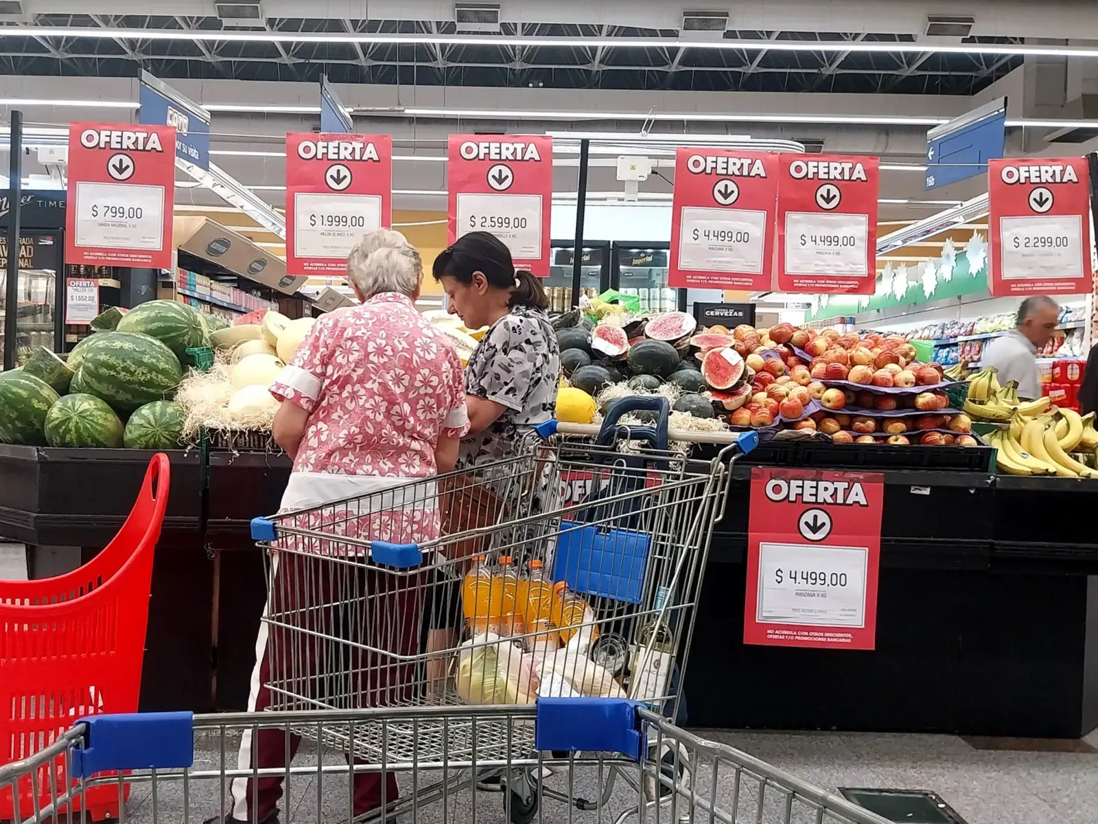 Góndola de supermercado en Argentina con precios en pesos y consumidores observando productos