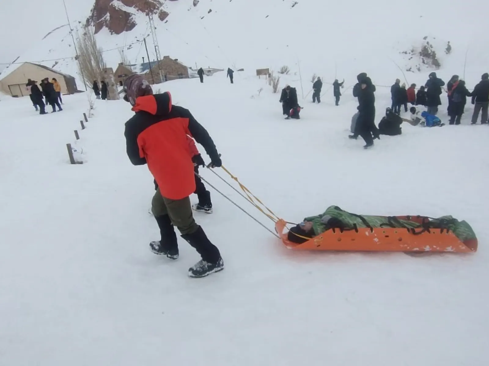 Turistas evacuados caminando entre nieve y viento en Puente del Inca, Mendoza, Argentina